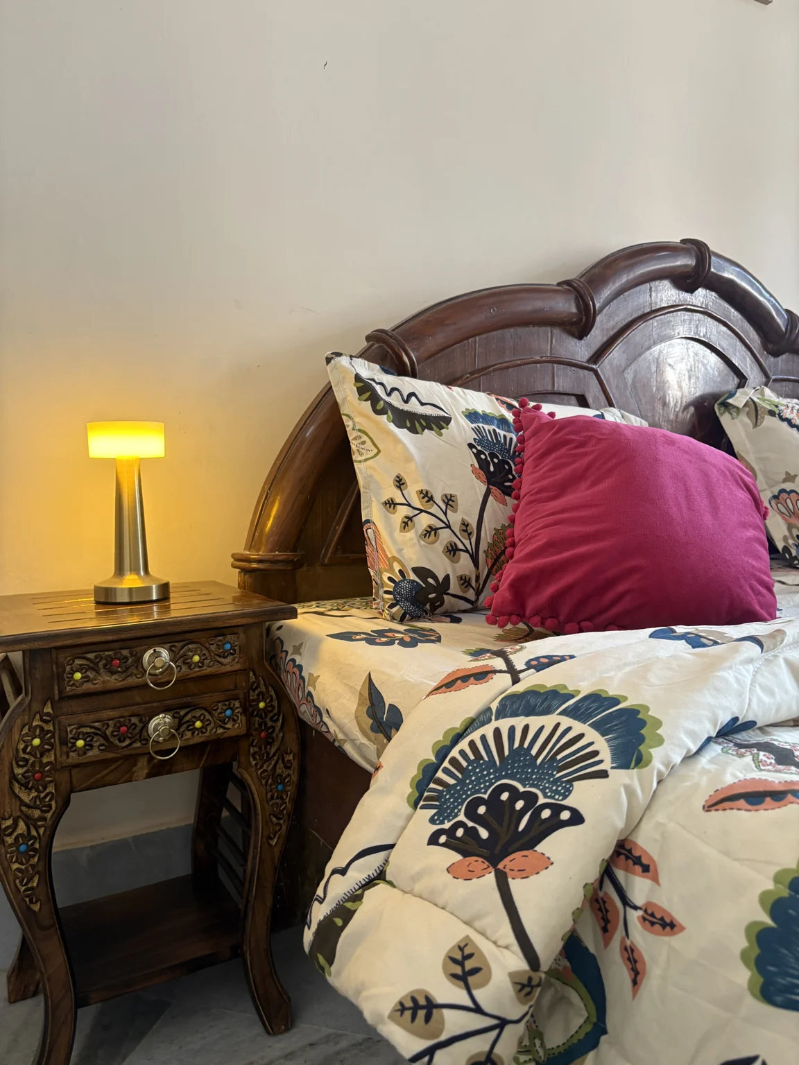 Carved bedside table with brass lamp