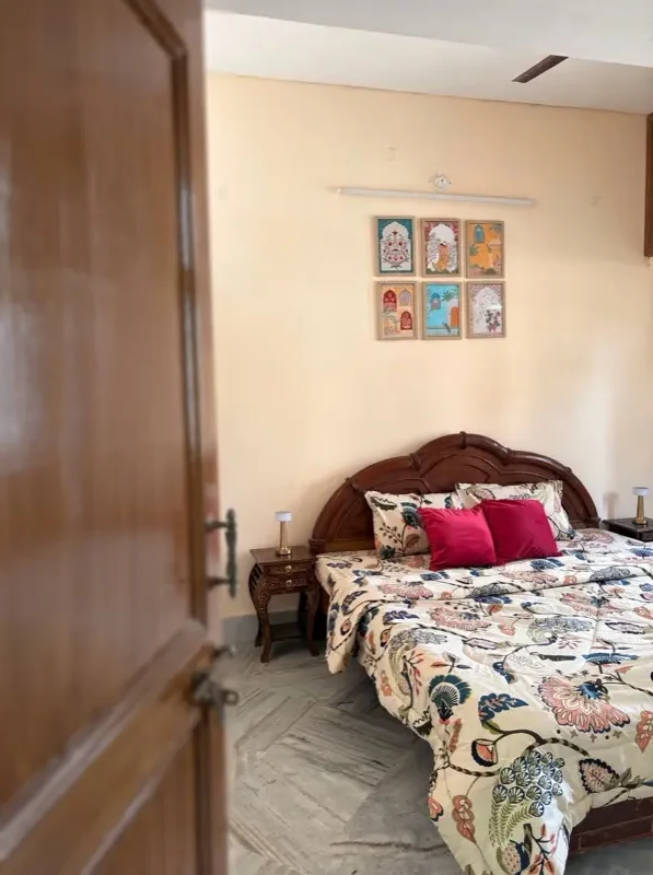 The bedroom through the door, floral bedding and wall art